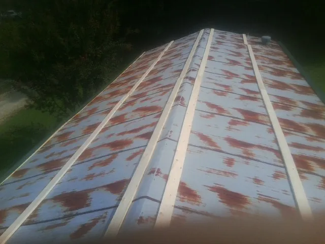 Rusted metal roof panels with new wood purlins before replacement — Storm Damage Roof Repair in Boring by Roofing Brothers
