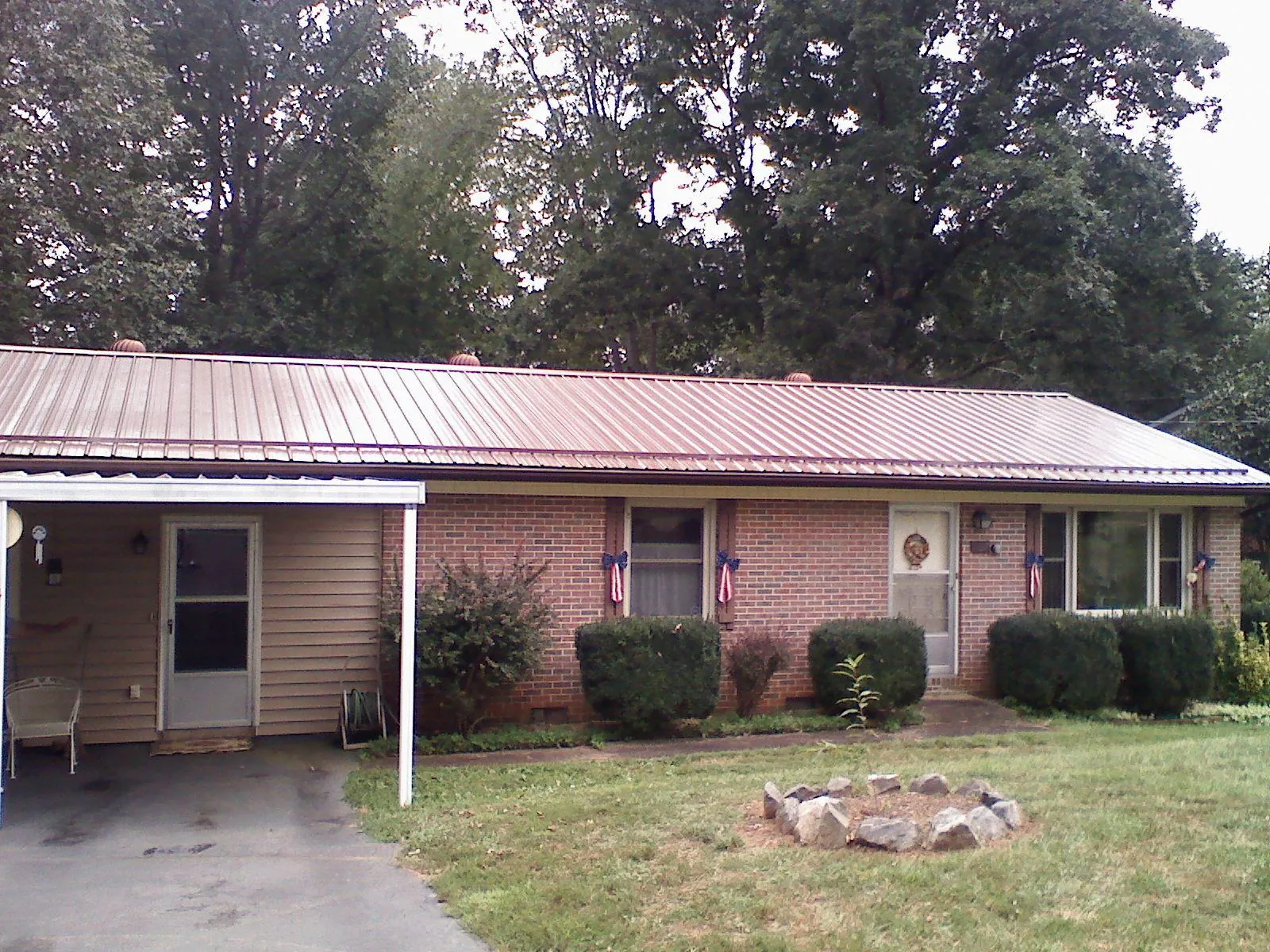 Bronze metal roof and carport on a brick ranch home — Roof Repair work by our crew in Boring